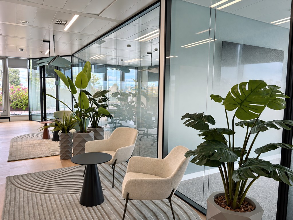 Area de espera de las oficinas Lincoln International con sillones y plantas