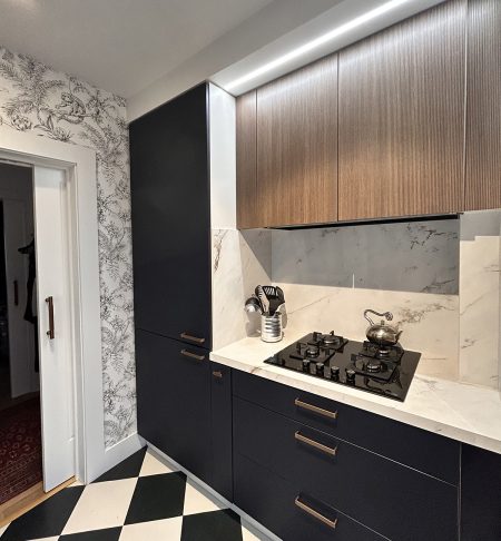 Diseno de cocina con placa de coccion, muebles de madera e iluminacion indirecta