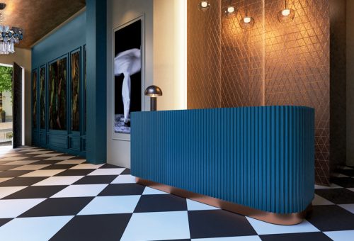 Recepción de proyecto hospitality con mostrador curvo azul y suelo damero